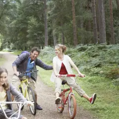 Rodzina na rowerach w lesie. Radosna prabuty trasa pełna śmiechu i słońca.