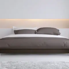 Elegante camera da letto con letto moderno e testata letto cartongesso illuminata, comodini con lampade e tappeto soffice.