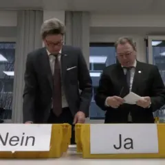 Männer bei einer Urabstimmung über einen Streik. Gelbe Boxen mit "Nein" und "Ja" stehen bereit.