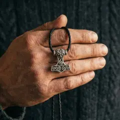 Dłoń trzyma wisiorek z młotem Thora, symbolem siły i ochrony. To jego znaczenie jest wciąż żywe.