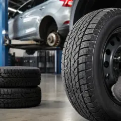 Werkstatt: Reifen werden montiert, ein Auto auf Hebebühne. Informiere dich über den reifen auswuchten preis für deine Sicherheit.