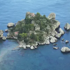 Isola Bella, una perla tra le spiagge della Sicilia orientale, con scogli e vegetazione lussureggiante.