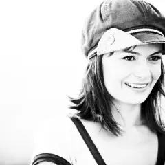 Sorriso contagioso di Lisa Lelli con un cappello alla marinara, in un ritratto in bianco e nero.