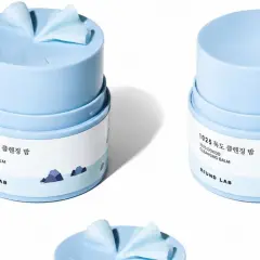 Zwei hellblaue Tiegel mit **Reinigungsbalsam** von Round Lab, beschriftet mit "1025 DOKDO CLEANSING BALM".