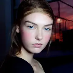 Ragazza con blush rosato sulle guance, un esempio di come scegliere il colore del blush per un look naturale.