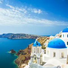 Santorini, gdzie leży Grecja, zachwyca białymi domkami i błękitnymi kopułami kościołów nad morzem.