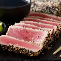 Trancio di tonno scottato con sesamo, pronto per gustose ricette. Accompagnato da wasabi, lime e salsa di soia.