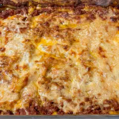 En gyllene, bubblande lasagne som precis kommit ur ugnen. Perfekt lasagne tid i ugn!