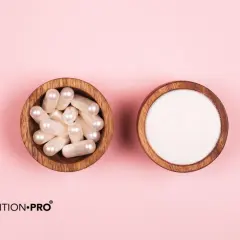 Deux bols en bois sur fond rose : l'un contient des gélules nacrées, l'autre de la poudre blanche. Le collagène marin dangers : une question à explorer.