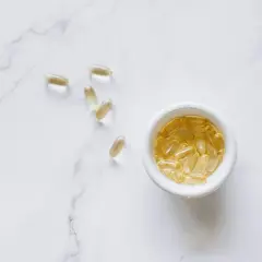 Gelkapseln, die Quercetin enthalten könnten, liegen auf Marmor.