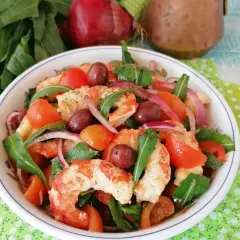 Deliziosa catalana di gamberi con pomodorini, olive, cipolla rossa e rucola, un piatto fresco e colorato.