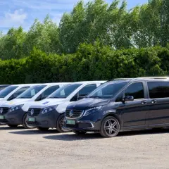 Rząd ciemnych i białych busów gotowych do przewozów busem po Polsce.