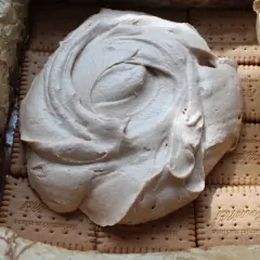 Ciasto Kinder Bueno z mascarpone w trakcie przygotowania. Kremowa masa rozpływa się na warstwie herbatników.