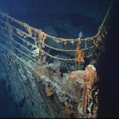 Proa del Titanic, una de las **titanic fotos reales**. Corrosión y vida marina cubren la barandilla oxidada en las profundidades del océano.