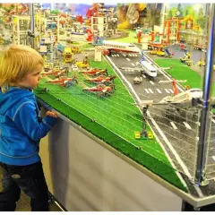 Chłopiec zafascynowany lotniskiem z klocków LEGO w Muzeum Klocków LEGO Kraków.