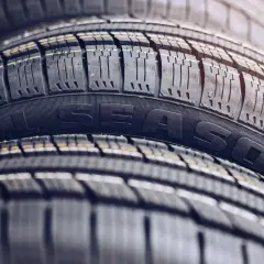 Stos opon wielosezonowych, z napisem "ALL SEASON". Czy w Niemczech można jeździć na oponach wielosezonowych?