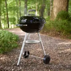 Barbecue noir avec couvercle, prêt pour un repas en plein air. Apprenez comment utiliser un barbecue avec couvercle pour des grillades parfaites.