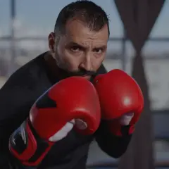 A focused boxer in red gloves, ready to implement his boxing strategy. His intense gaze suggests a well-thought-out plan.