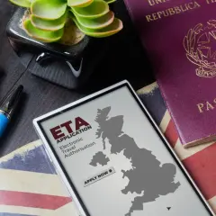 Telefon z mapą Wielkiej Brytanii i napisem "ETA APPLICATION" obok paszportu. Planujesz podróż do Londynu?