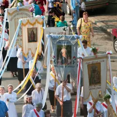 Procesja z chorągwiami religijnymi, 2 czerwca. Ludzie niosą obrazy Matki Bożej i świętych, uczestnicząc w uroczystości.