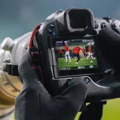 Aparat fotograficzny służy do uchwycenia dynamicznych momentów na boisku, jak ten piłkarz w akcji.