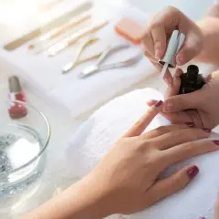 Manicure tytanowy krok po kroku: aplikacja lakieru na paznokcie, narzędzia do stylizacji w tle.