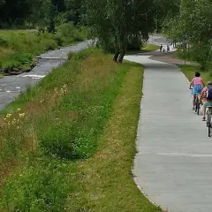 Rowerzyści na ścieżce wzdłuż potoku. Velo Krynica zaprasza do aktywnego wypoczynku na łonie natury.