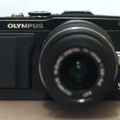 Czarny aparat Olympus E-PL5 z obiektywem.