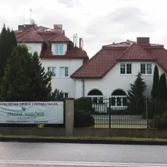 Budynek z czerwonym dachem i banerem "Zielone Wzgórze".