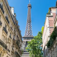 La Tour Eiffel se dresse entre des immeubles parisiens. Un aperçu parfait pour un paris visite pass.