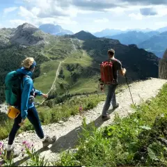 Dos personas disfrutan de un día de trekking hiking por un sendero montañoso con vistas espectaculares.