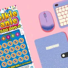 Zdrapka "Wielkie Granie" z szansą na 500 000 zł. Czy to klucz, jak wygrac w zdrapki? Obok klawiatura, myszka i notatnik.