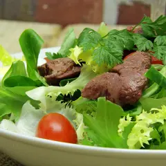 Salade de foies de volaille avec laitue, tomates cerises, œuf dur et persil.