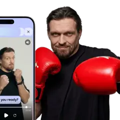 A boxer in red gloves, ready to throw down. The phone screen shows a video with the text "Are you ready?" - a real knockout!