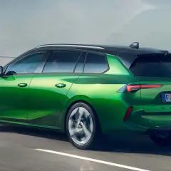 Zielony Opel Astra kombi, jeden z nowoczesnych opel modele, pędzi po drodze.