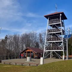 Wieża widokowa, altana i turbina wiatrowa na tle nieba.