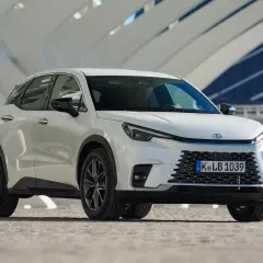 Biały Lexus LBX na tle nowoczesnej architektury. Sprawdź nasze lexus lbx opinie i przekonaj się o jego zaletach.