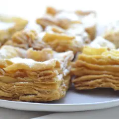 Deliciosos pastelitos de hojaldre con azúcar glas. El hojaldre, con sus capas crujientes y doradas, invita a probarlos.