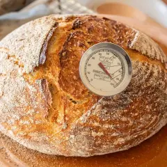Pan artesanal recién horneado, listo para disfrutar. El termómetro indica la temperatura perfecta para hacer pan con masa madre.
