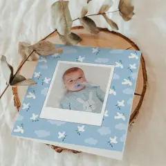 Carte de baptême avec photo d'un bébé, décorée de colombes et de nuages. Parfait pour trouver les mots pour baptême.