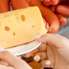 Mano prende una fetta di formaggio svizzero dal frigorifero. Quanto dura il formaggio spalmabile aperto?