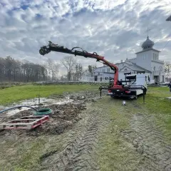 Dźwig z HDS pracuje przy studni, zapewniając własne ujęcie wody dla zabytkowego budynku.