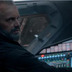 Un homme barbu, casque sur les oreilles, aux commandes d'un vaisseau spatial. L'avenir de l'humanité est en jeu dans For All Mankind saison 5.