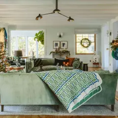 A cozy living room with a decorated Christmas tree, stockings hung by the fireplace, and a festive holiday design.