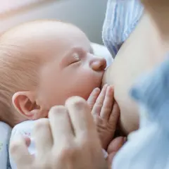 Malutkie rączki otulają pierś mamy. Karmienie piersią to piękny moment, w przeciwieństwie do palenia papierosów, które szkodzi dziecku.