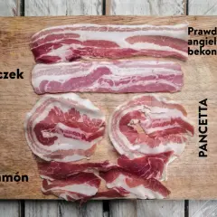Różne rodzaje mięsa: boczek, prawdziwy angielski bekon, pancetta i jamón, ułożone na desce.
