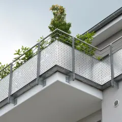 Nowoczesny balkon z ażurową balustradą i zielenią. Solidna hydroizolacja balkonu zapewnia trwałość i komfort użytkowania.