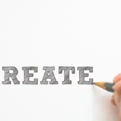 Un cartel curso con la palabra "CREATE" escrita a lápiz. Una mano dibuja la última letra, invitando a la creatividad.