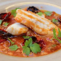 Deliciosa ventresca de merluza en salsa de tomate con pimientos secos y perejil fresco.