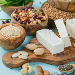 Vielfalt an vegetarischen Proteinquellen: Quinoa, Hülsenfrüchte, Tofu, Nüsse, Samen und Brokkoli.